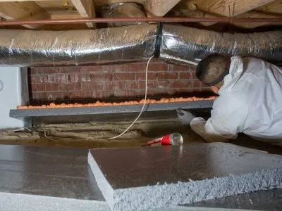 crew member installing crawl space insulation panels